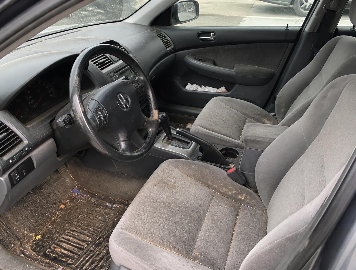 Dirty car interior with stained seats and debris before detailing