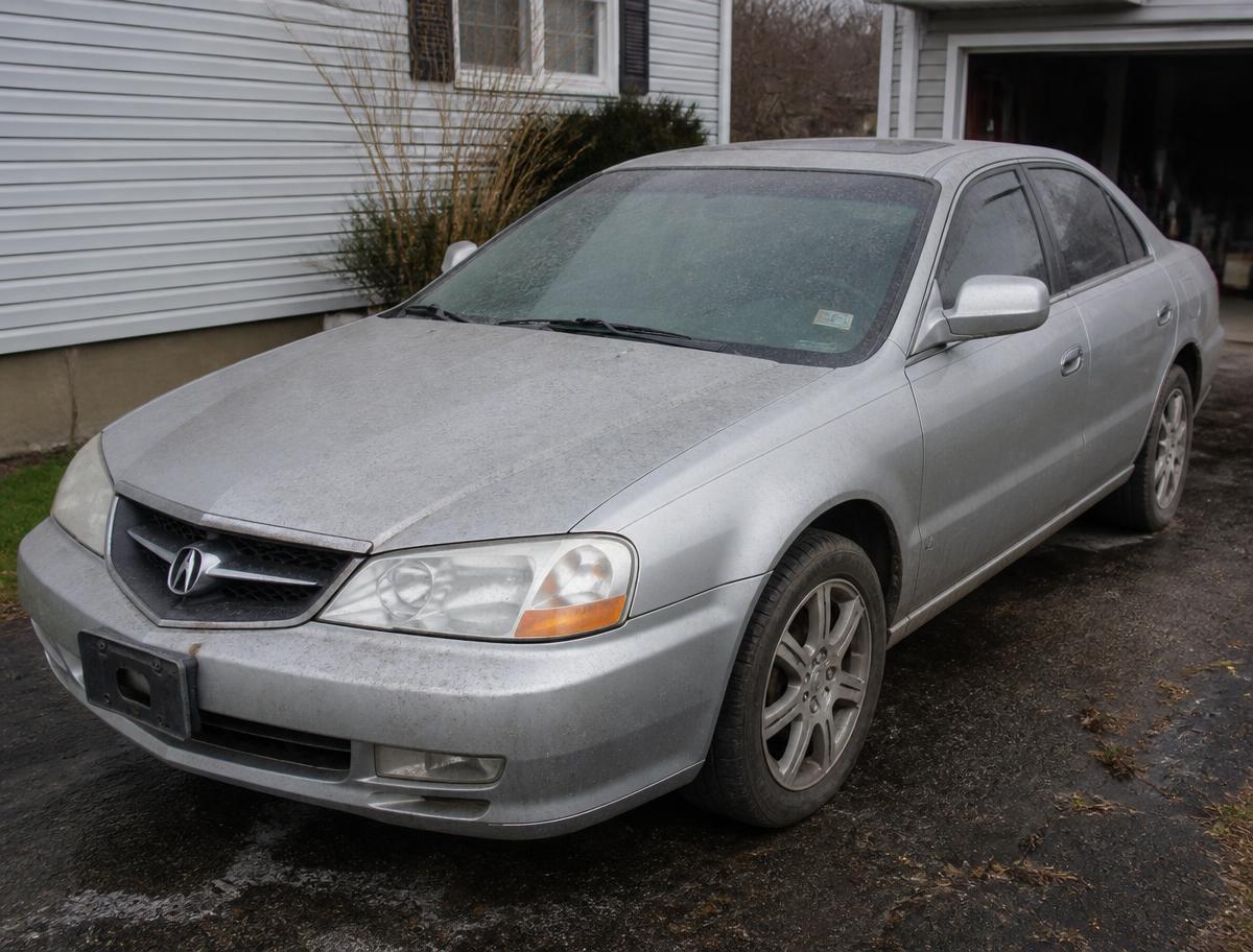 Dusty silver sedan covered in road grime before detailing
